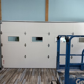Indoor commercial garage door installation with high-lift track at Diverse Options in Ripon, WI