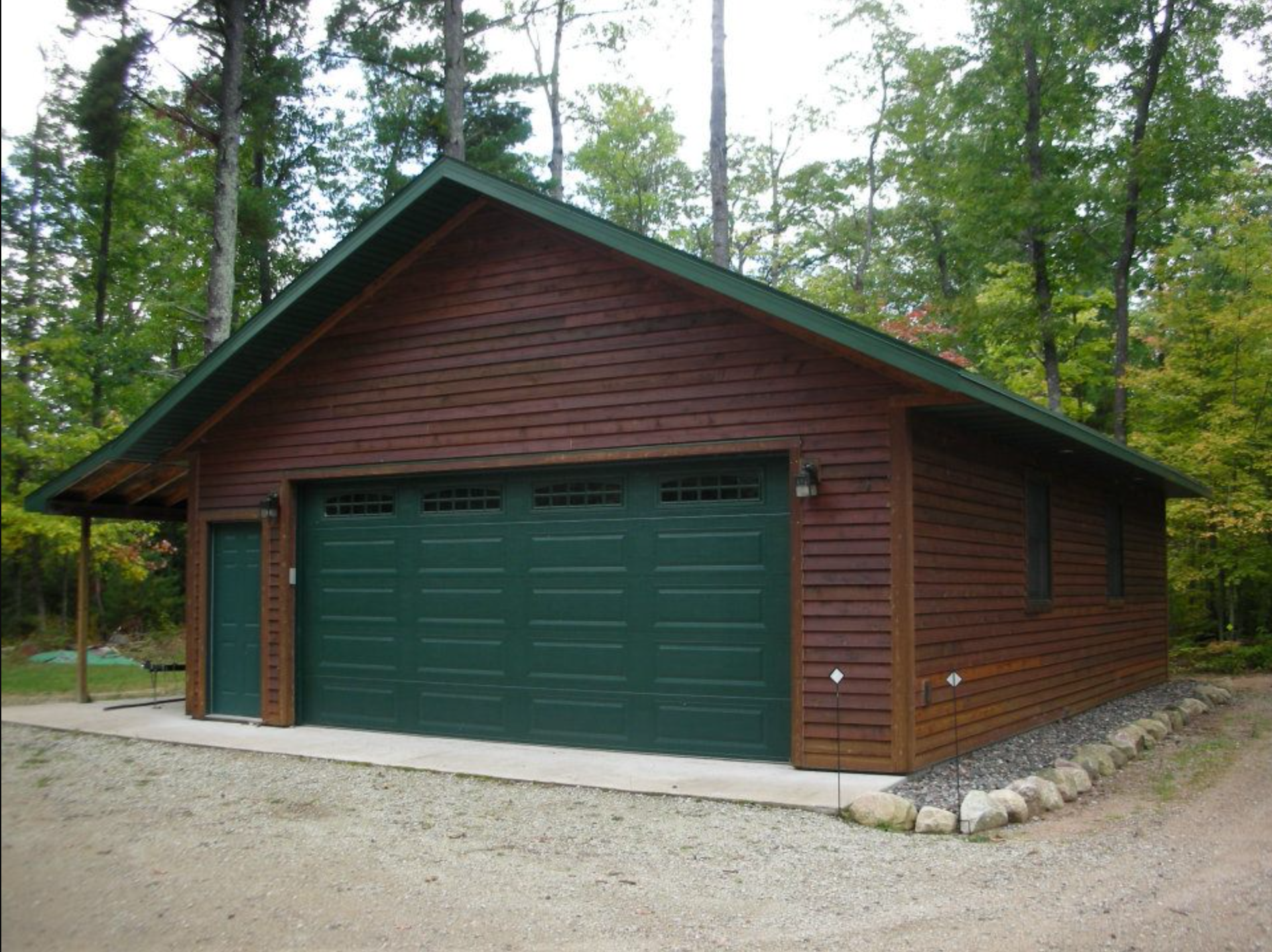 Brown wood home with green garage doors